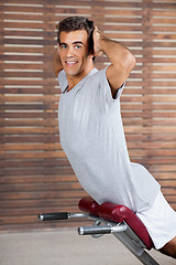 Image showing Young Man Exercising On Machine In Health Club