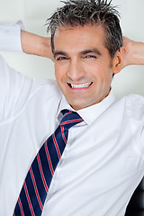 Image showing Mid Adult Businessman Relaxing With Hands Behind Head