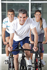 Image showing Men And Woman On Spinning Bikes