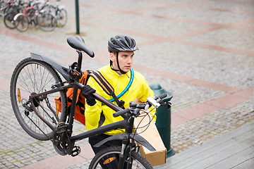Image showing Courier Delivery Man With Package And Bicycle Walking Up Steps