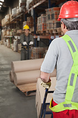 Image showing Warehouse Workers Pushing Handtruck