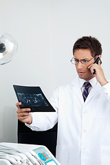 Image showing Dentist On Call As He Checks X-Ray Report