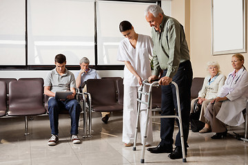 Image showing Man Being Helped By Nurse To Walk Zimmer Frame