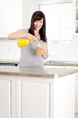 Image showing Pregnant Woman pouring Orange Juice