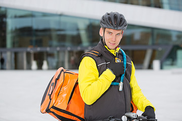 Image showing Cyclist With Courier Delivery Bag Using Walkie- Talkie