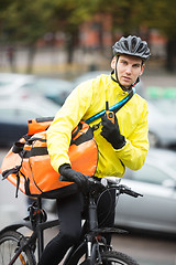 Image showing Male Cyclist With Courier Bag Using Walkie-Talkie On Street