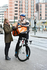 Image showing Young Woman Receiving A Package From Courier Delivery Man