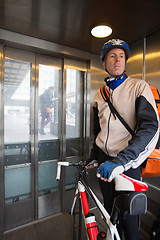 Image showing Male Cyclist With Courier Bag Riding In An Elevator