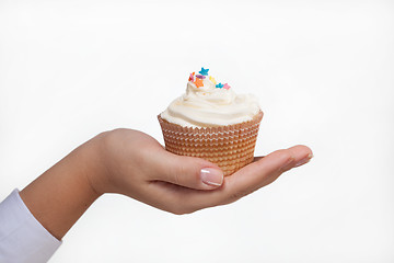 Image showing hand holding a cupcake isolated on white