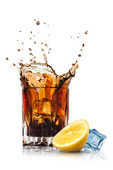 Image showing splash of cola in glass with lemon and ice isolated on white