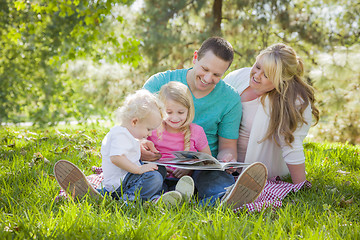 Image showing Young Family Enjoys Reading a Book in the Park
