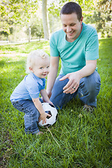 Image showing Young Boy and Dad Playing with Soccer Ball in Park