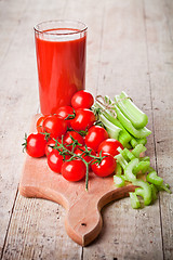 Image showing tomato juice in glass, fresh tomatoes and green celery 