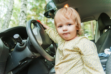 Image showing Little blond girl driving car