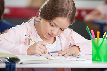 Image showing Schoolgirl Drawing At Desk