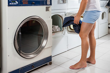 Image showing Man Putting Clothes In Washing Machine