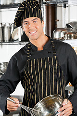 Image showing Young Chef Holding Wire Whisk And Mixing Bowl