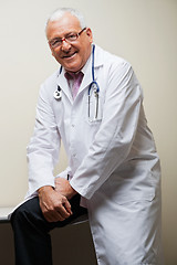 Image showing Senior Doctor Sitting On Desk