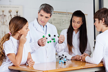 Image showing Teacher With Students Analyzing Molecular Atoms At Desk