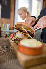 Image showing Man With Burger And Sauce On Wooden Plate