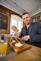 Image showing Businessman Having Food With Colleague In Coffeeshop