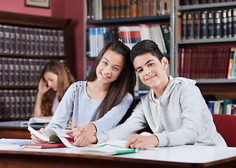 Image showing Girlfriend And Boyfriend Holding Hands At Table In School Librar