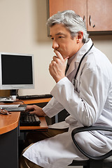 Image showing Pensive Doctor Sitting At Desk
