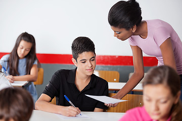 Image showing Teacher Showing Paper To Teenage Schoolboy During Examination