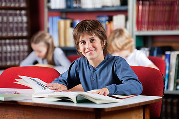 Image showing Schoolboy Smiling With Books At Table In Library