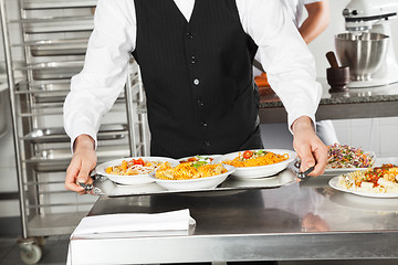 Image showing Waiter Holding Pasta Dishes In Tray