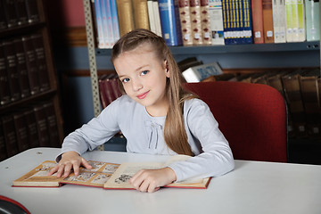 Image showing Little Girl Sitting At Table With Books