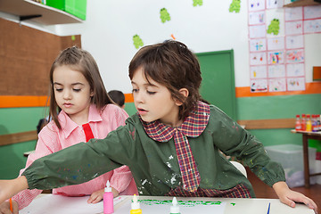 Image showing Boy With Girl Painting At Classroom Desk