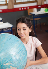Image showing Schoolgirl Smiling While Searching Places On Globe
