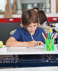 Image showing Little Schoolboy Studying At Desk