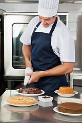 Image showing Chef decorating sweet food with piping bag