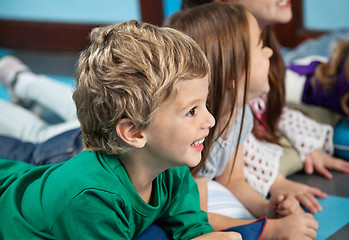 Image showing Boy With Friends Lying On Floor In Kindergarten