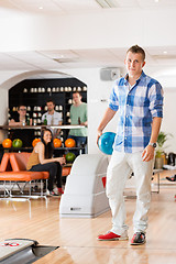 Image showing Young Man Holding Bowling Ball in Club