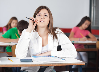 Image showing Thoughtful Female Student Looking Up At Desk