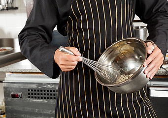 Image showing Male Chef Whisking Egg In Kitchen