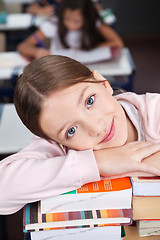 Image showing Happy Schoolgirl Leaning On Stack Of Books