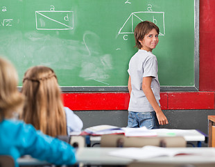 Image showing Little Boy Standing By Board In Classroom