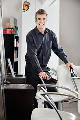 Image showing Happy Hairstylist Holding Straightener And Brush