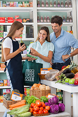 Image showing Saleswoman Showing Vegetable Packet To Couple