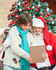 Image showing Boy Showing Digital Tablet To Santa Claus