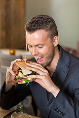 Image showing Young Businessman Eating Sandwich