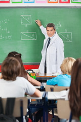 Image showing Teacher Teaching While Writing On Board