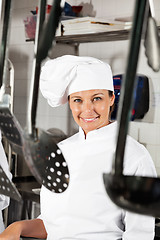 Image showing Female Chef With Spoons Hanging In Foreground