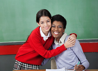 Image showing Happy Schoolgirl Hugging Professor In Classroom