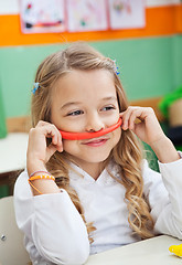 Image showing Girl Holding Mustache Made Of Clay In Classroom