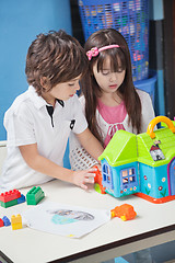 Image showing Boy And Girl Playing With Plastic House In Kindergarten